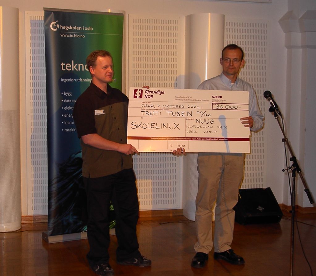 Vidar Bakke overrekker premien (en sjekk p� 30 000,-) til Skolelinux v/Knut Yrvin.